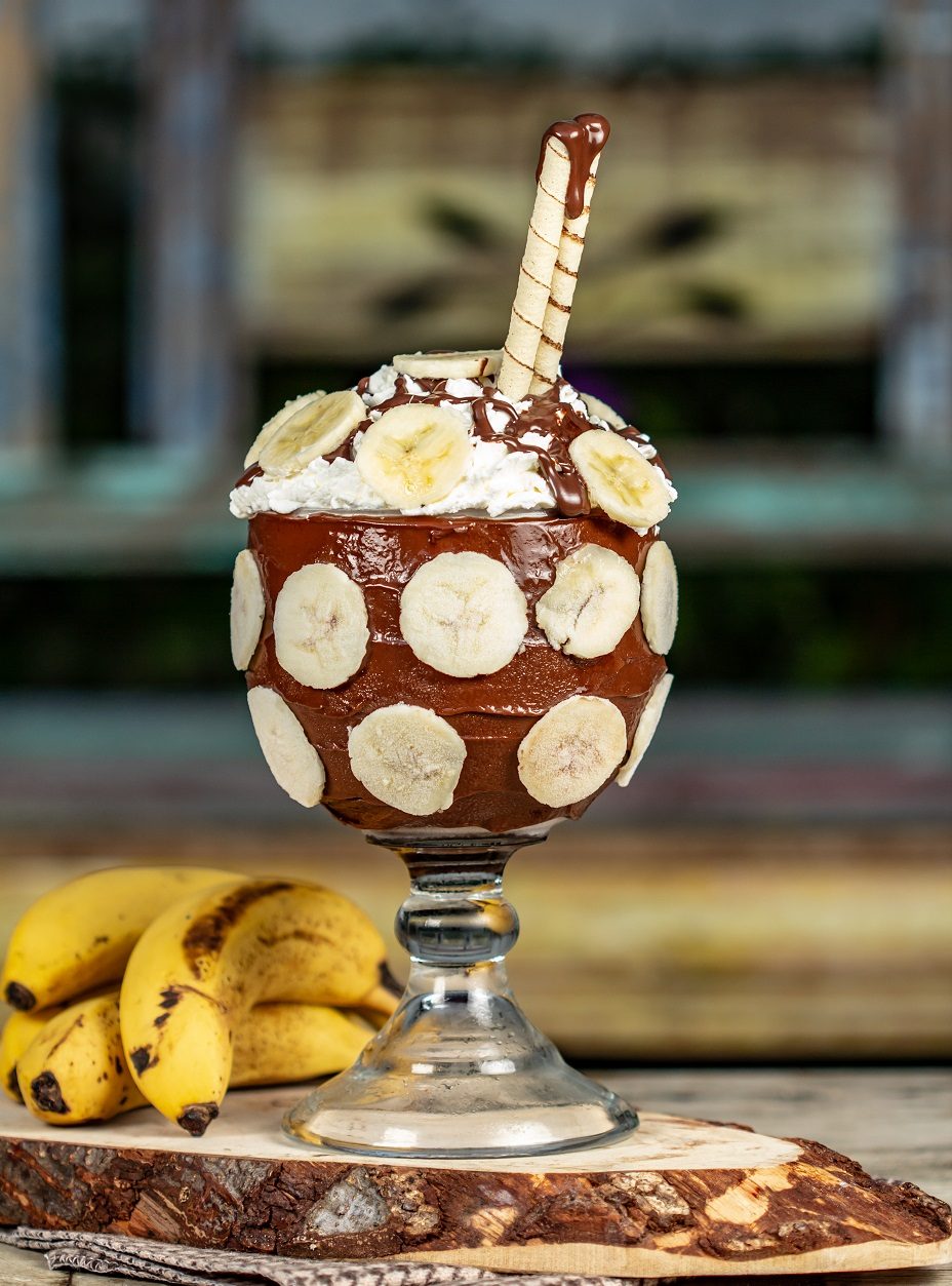 Taça Banatella com fatias de banana ao redor e cobertura de chocolate